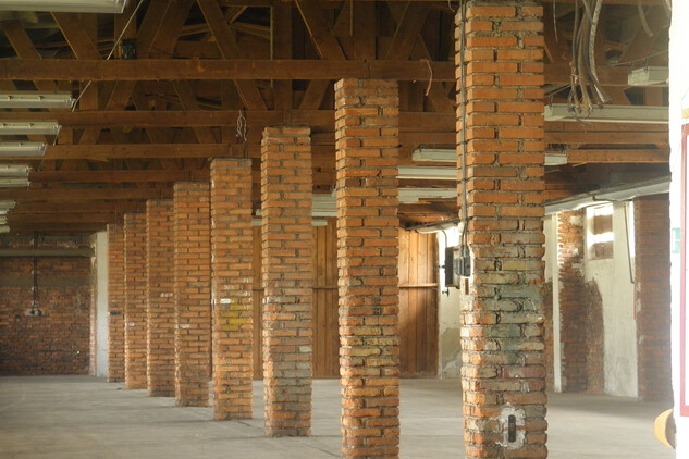 Pohled ve skladové hale v r. 2011 – v době provozu drtírny, by tu návštěvník viděl ocelové barely naplněné uranovou rudou ve čtyřech pěti vrstvách na sobě Pohled ve skladové hale v r. 2011 – v době provozu drtírny, by tu návštěvník viděl ocelové barely naplněné uranovou rudou ve čtyřech pěti vrstvách na sobě